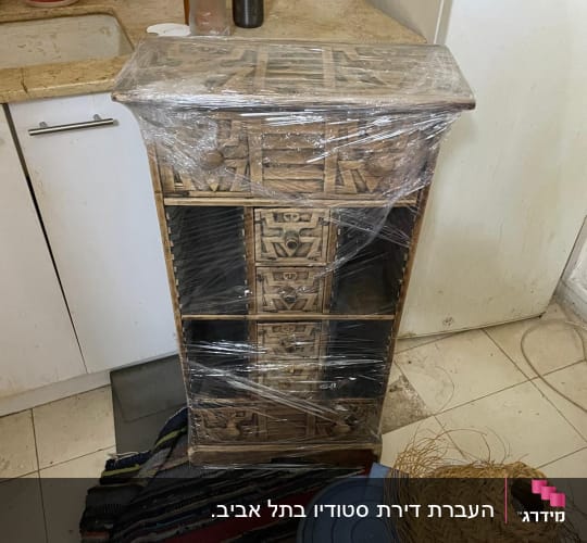 רהיט עטוף בניילון במטבח, מוכן להובלה